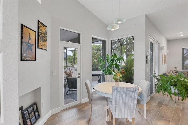 dining area with lofted ceiling and light hardwood / wood-style floors