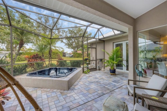 view of patio / terrace featuring french doors, glass enclosure, and an outdoor hot tub