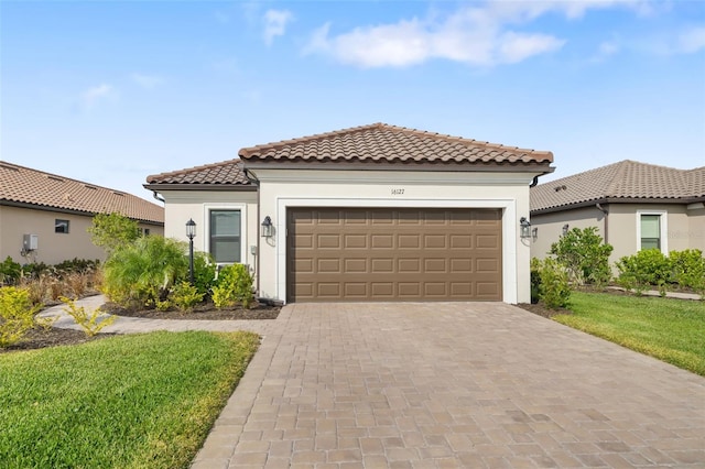 mediterranean / spanish home featuring a front lawn and a garage