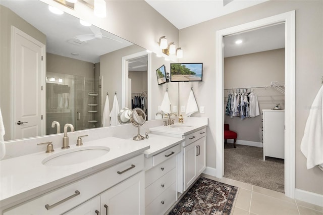 bathroom with walk in shower, vanity, and tile patterned floors