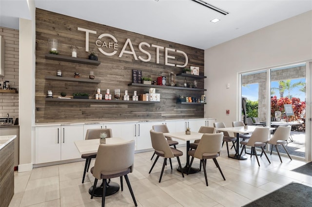 bar featuring white cabinets, wood walls, and light tile patterned floors