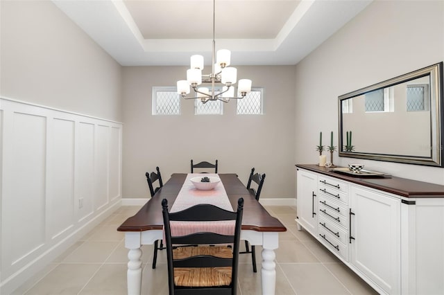 16127 Fortezza Dr, Bradenton, FL 34211 - dining space featuring a chandelier, light tile patterned floors, a raised ceiling, and a decorative wall