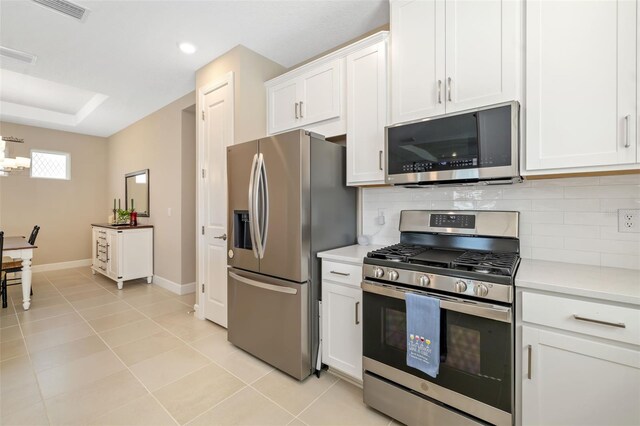 16127 Fortezza Dr, Bradenton, FL 34211 - kitchen featuring stainless steel appliances, backsplash, light countertops, white cabinets, and light tile patterned floors