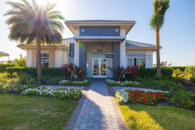 16127 Fortezza Dr, Bradenton, FL 34211 - view of front of house featuring french doors, a front yard, and stucco siding