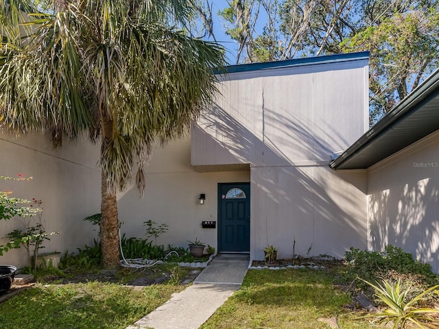 entrance to property with a lawn