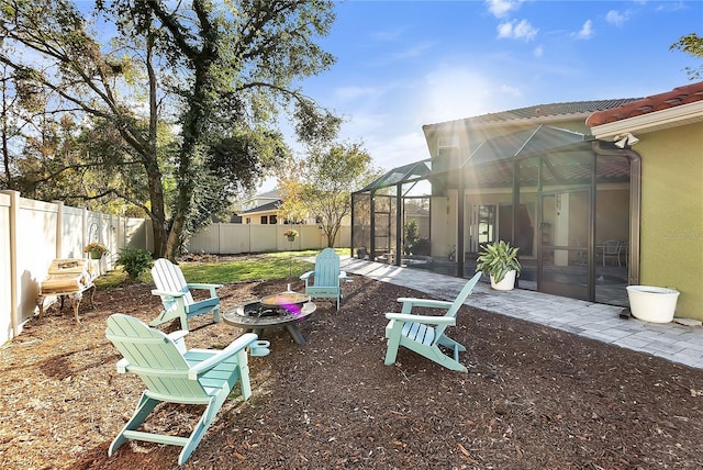 view of yard with an outdoor fire pit, glass enclosure, and a patio area