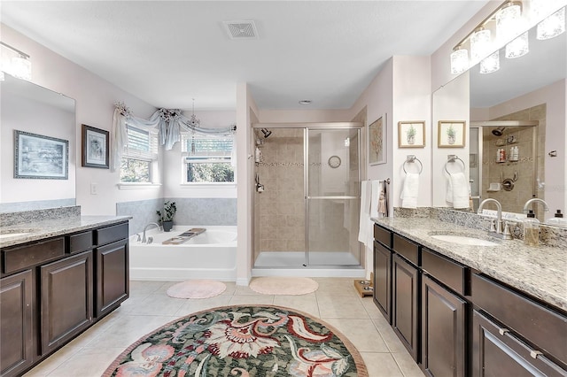 full bath featuring tile patterned flooring, two vanities, a stall shower, a bath, and a sink