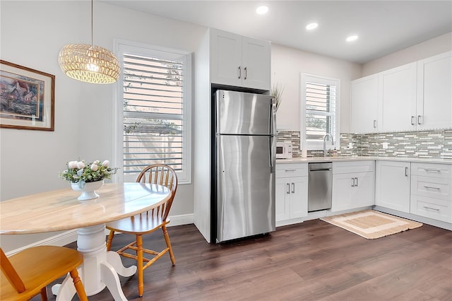 kitchen featuring backsplash, recessed lighting, stainless steel appliances, light countertops, and dark wood-style flooring