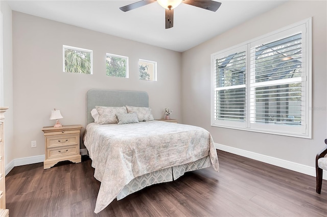 bedroom with baseboards, multiple windows, and dark wood-style flooring