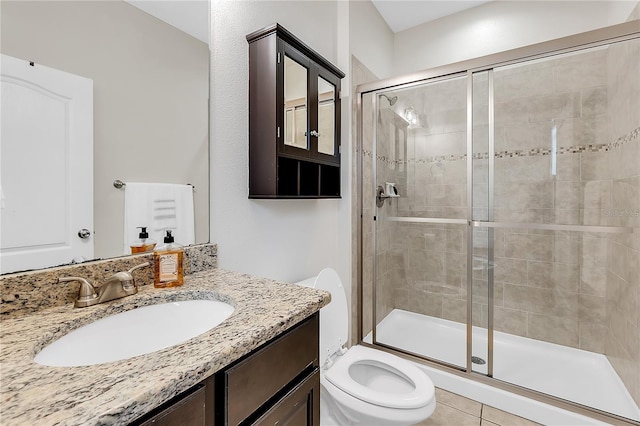 bathroom with a shower with door, tile patterned floors, vanity, and toilet