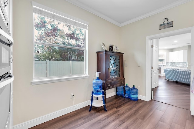 interior space with dark wood finished floors, baseboards, and ornamental molding