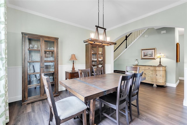 dining area featuring stairs, crown molding, dark wood-style floors, and arched walkways