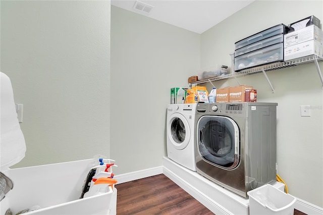 washroom with wood finished floors, visible vents, baseboards, laundry area, and independent washer and dryer