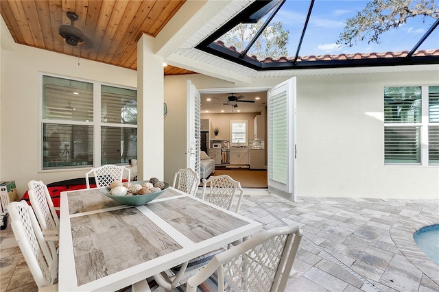 dining area with wood ceiling, a ceiling fan, and stone tile floors