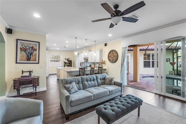 living room with ornamental molding, dark wood-style floors, recessed lighting, a ceiling fan, and baseboards