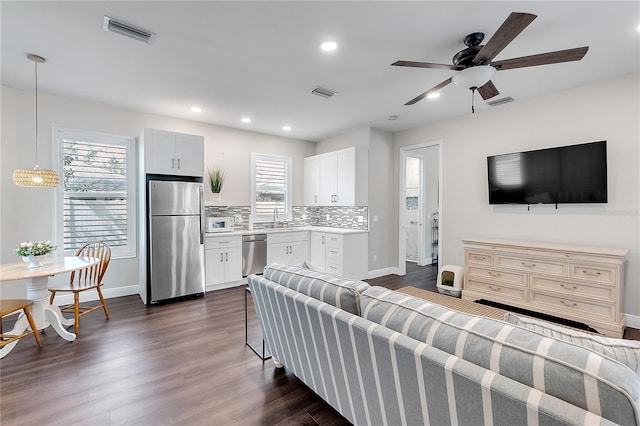 living area with baseboards, dark wood finished floors, a ceiling fan, and recessed lighting