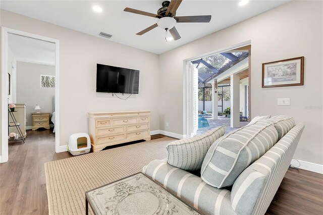 living room with baseboards, ceiling fan, wood finished floors, and visible vents