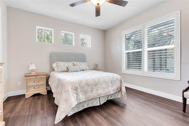 bedroom with dark wood-style flooring, multiple windows, and baseboards