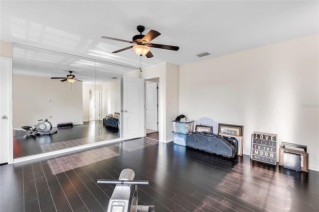 exercise room featuring ceiling fan, wood finished floors, and baseboards