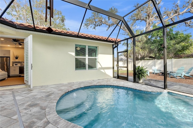 view of pool featuring a patio area, a lanai, and a ceiling fan