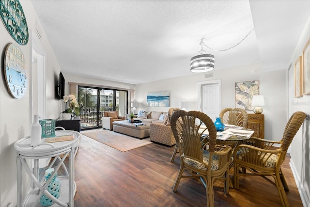 dining room featuring a notable chandelier, a textured ceiling, and hardwood / wood-style floors