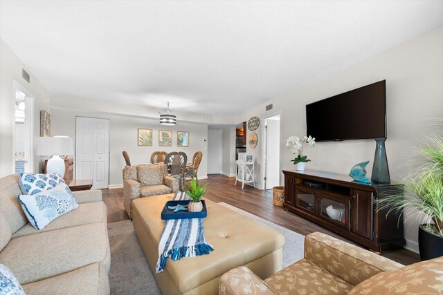 living room featuring a chandelier and wood-type flooring