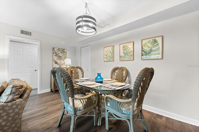 dining area featuring an inviting chandelier and dark hardwood / wood-style flooring