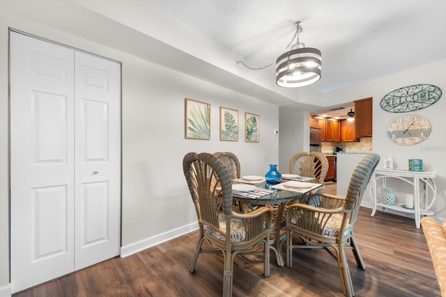 dining room featuring a textured ceiling, dark hardwood / wood-style flooring, and an inviting chandelier