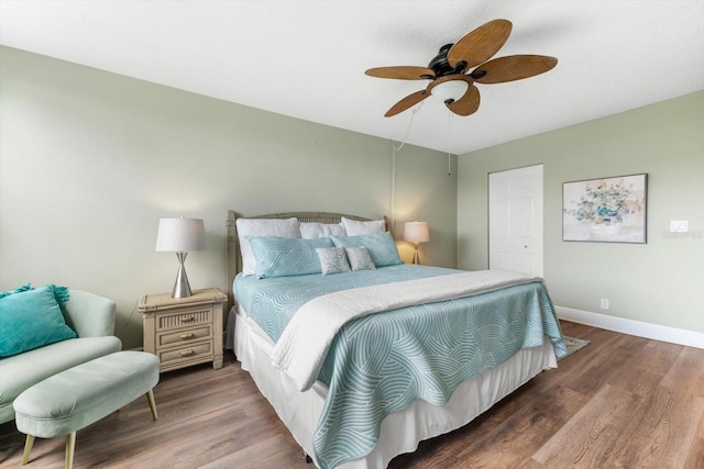 bedroom with ceiling fan, a closet, and dark wood-type flooring