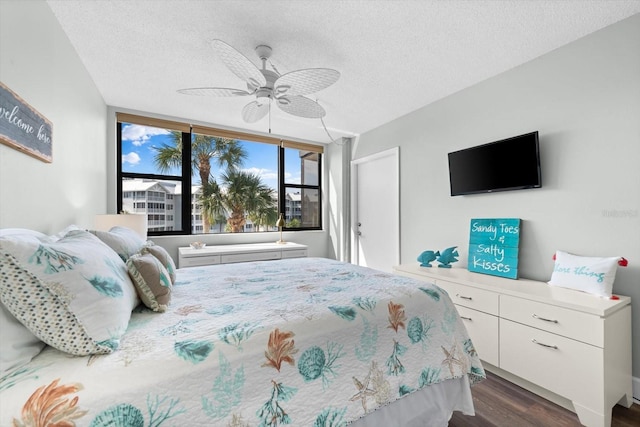 bedroom with ceiling fan, dark hardwood / wood-style floors, and a textured ceiling