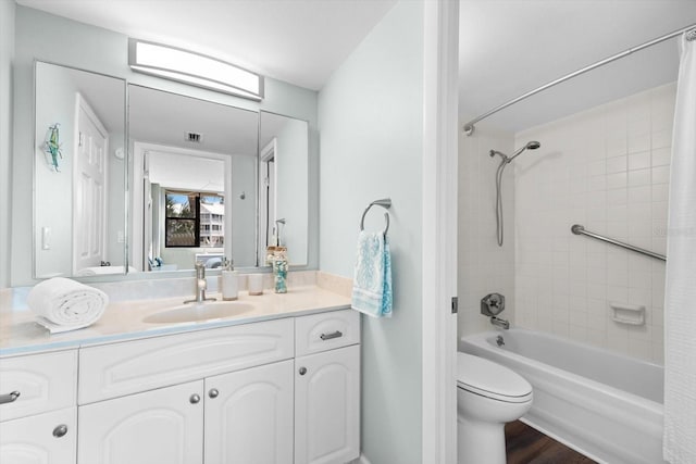 full bathroom featuring toilet, hardwood / wood-style floors, vanity, and shower / tub combo with curtain