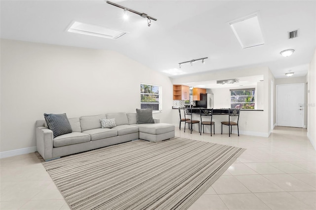 tiled living room featuring lofted ceiling and a wealth of natural light