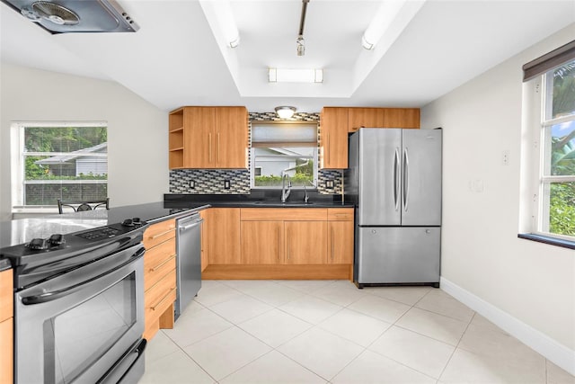 kitchen with appliances with stainless steel finishes, sink, track lighting, and plenty of natural light