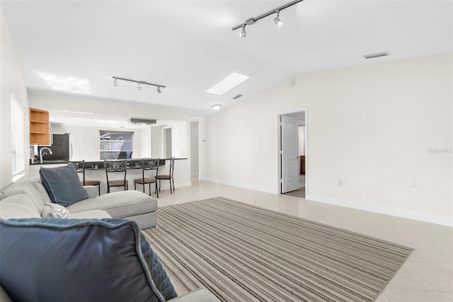 tiled living room featuring vaulted ceiling and sink