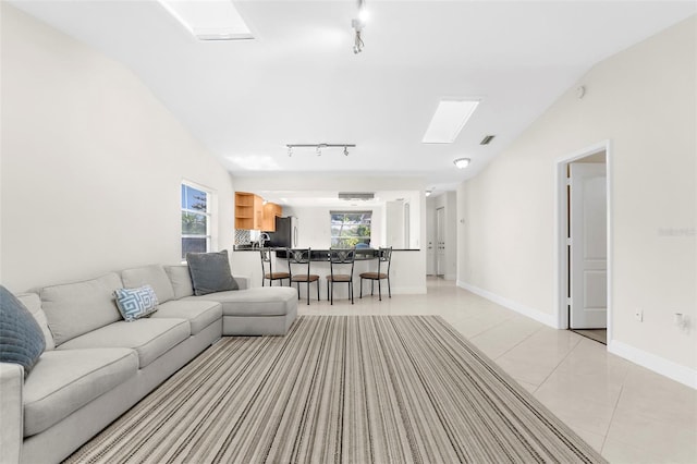 living room featuring a wealth of natural light, light tile patterned floors, and lofted ceiling