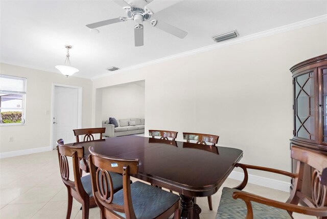 tiled dining area featuring ceiling fan and ornamental molding