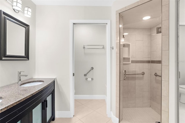 bathroom featuring toilet, vanity, tile patterned flooring, and an enclosed shower