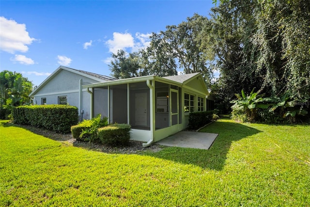 view of side of home featuring a sunroom and a lawn