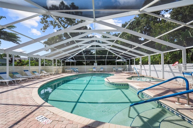 view of pool featuring an in ground hot tub, glass enclosure, and a patio