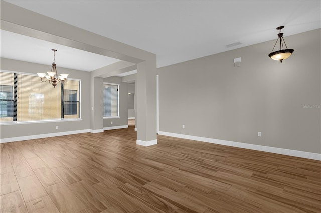 unfurnished living room featuring hardwood / wood-style floors and a notable chandelier