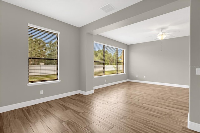 empty room with ceiling fan and light hardwood / wood-style floors