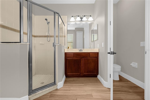 bathroom with hardwood / wood-style flooring, toilet, an enclosed shower, and vanity