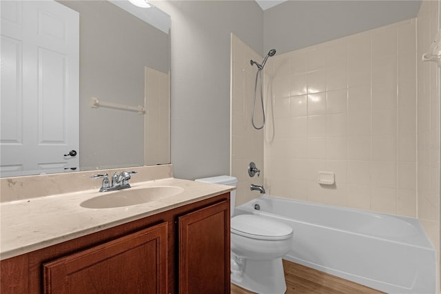 full bathroom with tiled shower / bath combo, hardwood / wood-style flooring, toilet, and vanity