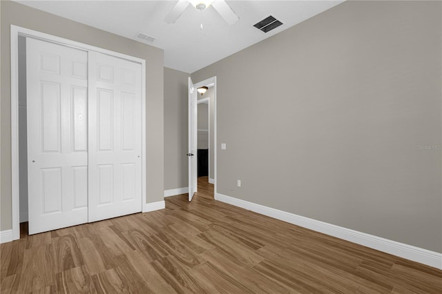 unfurnished bedroom with a closet, ceiling fan, and hardwood / wood-style flooring