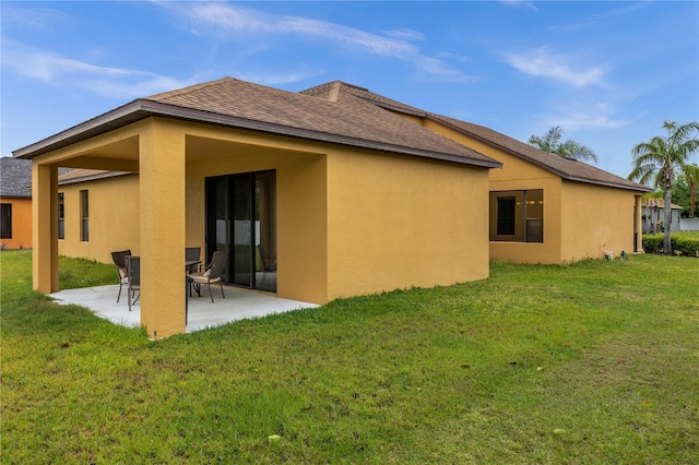 rear view of property featuring a yard and a patio