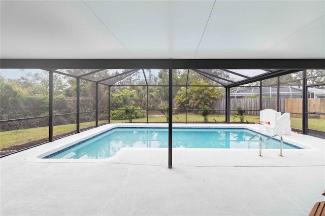 view of swimming pool featuring a yard, a patio area, and glass enclosure