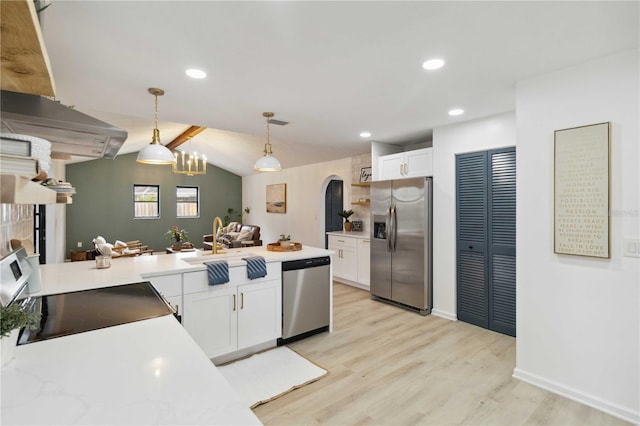 kitchen with decorative light fixtures, lofted ceiling, sink, appliances with stainless steel finishes, and white cabinets