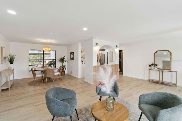 living room featuring light hardwood / wood-style floors and a chandelier