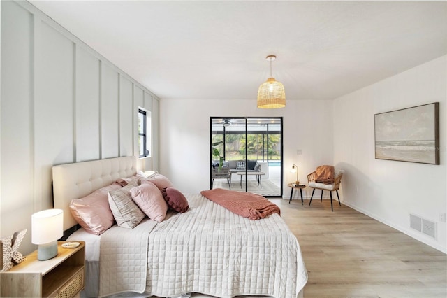 bedroom with light wood-type flooring and access to exterior