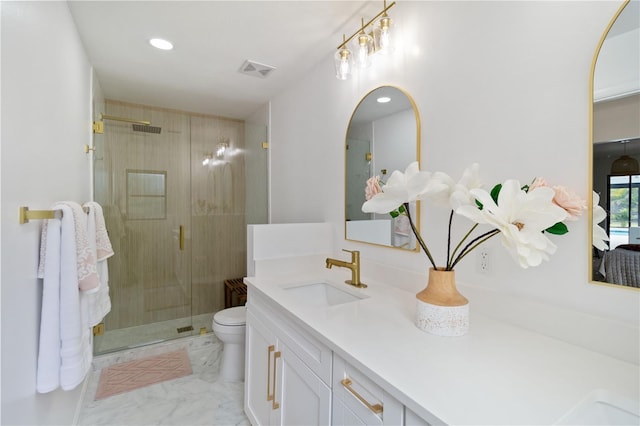 bathroom with toilet, vanity, and a shower with door